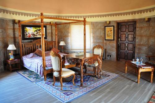 a bedroom with a canopy bed and a table and chairs at Welcomhotel by ITC Hotels, Fort & Dunes, Khimsar in Khimsar