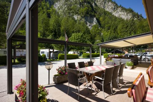a patio with a table and chairs and a mountain at Ferienwohnungen Karwendel Camping in Maurach