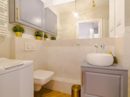 a bathroom with a sink and a toilet and a mirror at Apartament 59 Dwie Sosny in Ustronie Morskie