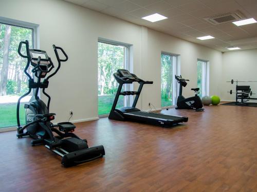 a gym with several treadmills and exercise bikes at Apartament 59 Dwie Sosny in Ustronie Morskie