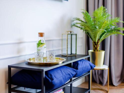 a black console table with a tray and a plant at Apartament 59 Dwie Sosny in Ustronie Morskie