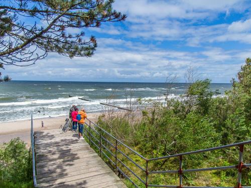 a group of people walking down the stairs to the beach at Apartament 59 Dwie Sosny in Ustronie Morskie
