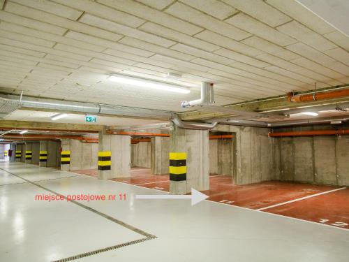 an empty parking garage with a white floor and ceiling at Apartament 59 Dwie Sosny in Ustronie Morskie