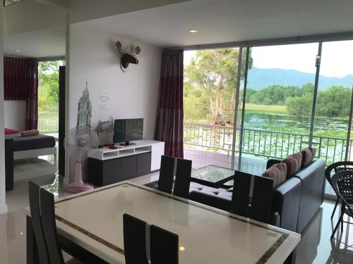 a living room with a table and a large window at Saree Lagoon Villa Koh Samui in Lipa Noi