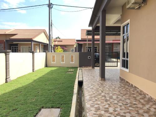 a courtyard of a house with a grass yard at Ana Guest House Jalan Airport Kuantan in Kuantan
