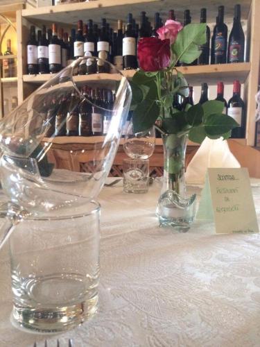 a table with a vase of flowers and wine bottles at Historic Hotel Ristorante La Stua in Cavalese