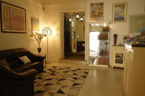 a living room with a couch and a refrigerator at Hotel le Préjoly in Saint-Vallier-de-Thiey