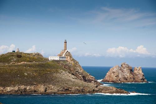 a lighthouse on a small island in the ocean at CA Apartamentos Pampin Ponte do Porto in Ponte Do Porto