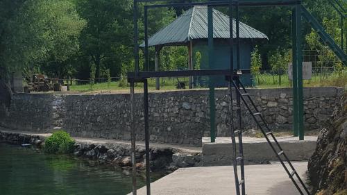 a cage on a tripod next to a pond at Apartment Sajra in Kulen Vakuf