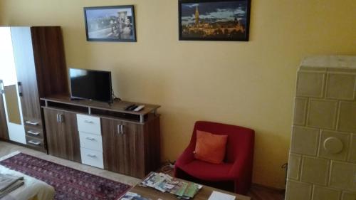 uma sala de estar com uma cadeira vermelha e uma televisão em Cute apartment close to the center em Budapeste