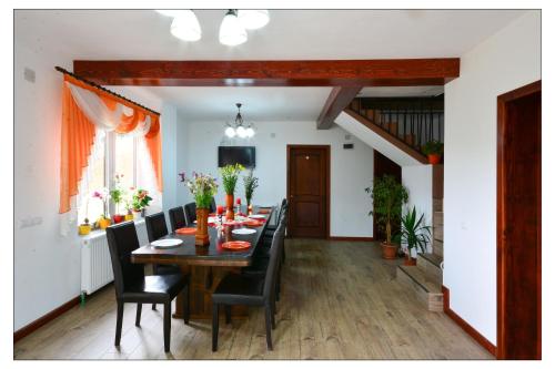 a dining room with a long table and black chairs at Pensiunea 7 Brazi in Poiana Mărului