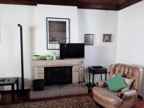a living room with a fireplace and a television at Casa de Santo Amaro in Vila do Conde