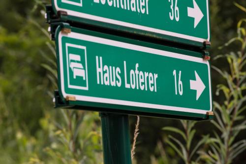 two green street signs on top of a pole at Haus Loferer in Sankt Martin bei Lofer