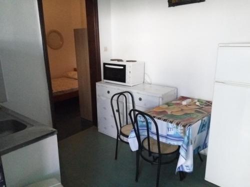 een kleine keuken met een kleine tafel en een magnetron bij Marina's Rooms in Lipsoi