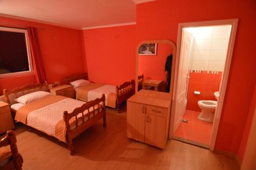 a red room with two beds and a bathroom at Hotel 24 jul in Pljevlja