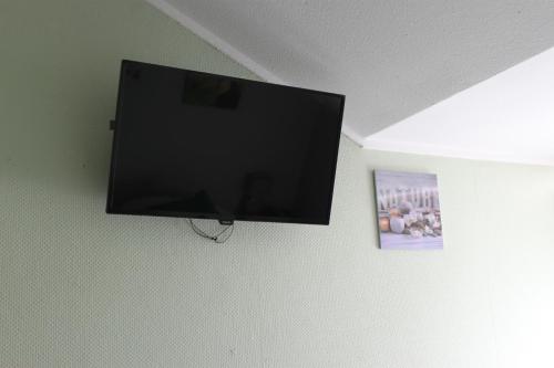 TV de pantalla plana colgada en la pared en Rene's B&B, en Kerkrade