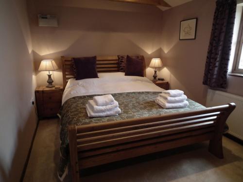 1 dormitorio con 1 cama con toallas en The Barn, Lower Spring, en Tavistock
