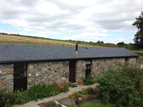 a man standing on the roof of a stone building at The Barn, Lower Spring in Tavistock