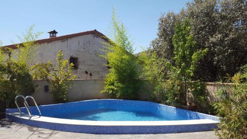 a swimming pool in the yard of a house at Casa Rural El Peral in Caminomorisco