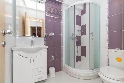 a bathroom with a sink and a toilet and a mirror at Apartments Villa-Ines Center in Vodice