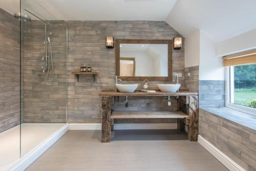 a bathroom with two sinks and a shower at Tyn Llain B&B in Llanfflewyn