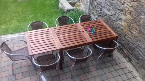 a wooden bench sitting on top of a table with chairs at La ferme de Bertogne in Bertogne