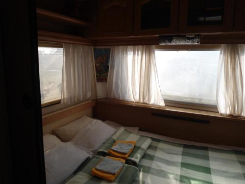 a small room with a bed and two windows at Granichar 1 Caravan in Granichar