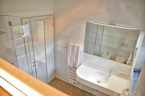 ein weißes Bad mit einem Waschbecken und einer Dusche in der Unterkunft Lindenhof Residence Meran in Meran