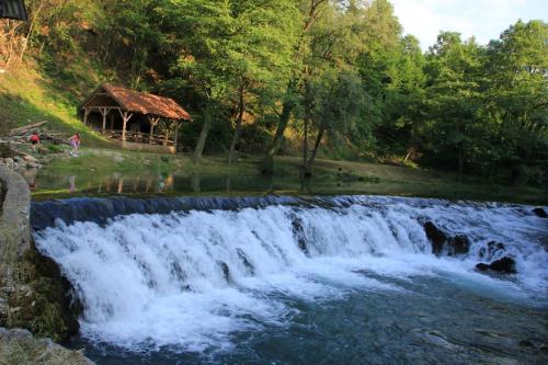 a waterfall with a gazebo next to a river at Apartment Snježana in Slunj