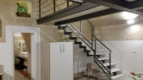 マテーラにあるLa Bomboniera Holiday Homeの洗面台付きの客室内の螺旋階段