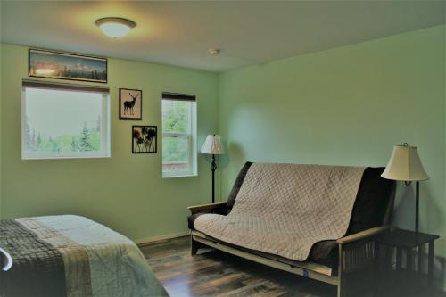 a bedroom with a bed and a chair and a window at Grace and Bill's Freedom Hills B&B in Talkeetna