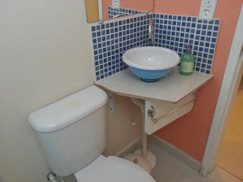 a bathroom with a white toilet and a sink at Pousada Porto Paraiso, o seu Paraíso Escondido no Guarujá in Guarujá