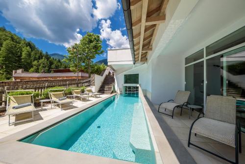 a swimming pool in the backyard of a house at Aparthotel Wellness Villa di Bosco in Tesero