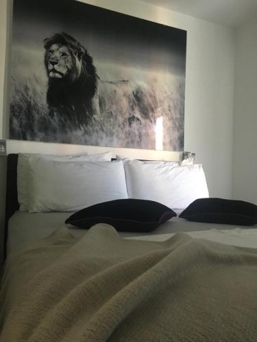 a painting of a lion above a bed with pillows at Casa di Lavanda in Hvar