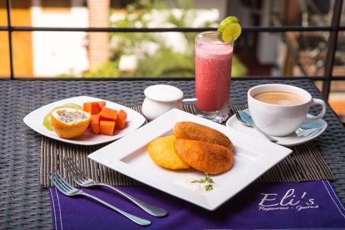 a table with two plates of food and a cup of coffee at Hotel Boutique Casa Carolina in Santa Marta