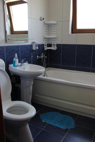a bathroom with a toilet and a sink and a bath tub at MIMOZA - Apartaments Panoramic Sea View in Eforie Nord