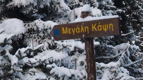 a sign that says mexican kuyuna in the snow at Livadaki Village in Megáli Kápsi