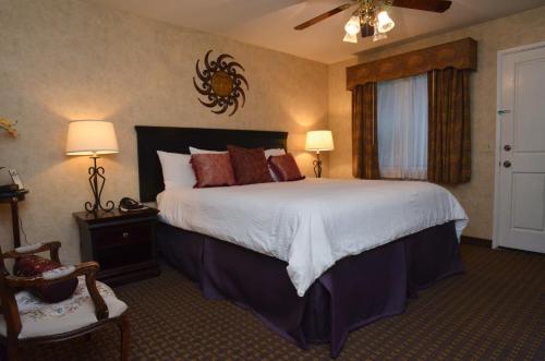 um quarto com uma cama grande e almofadas vermelhas em Rosedale Inn em Pacific Grove