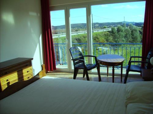 a bedroom with a bed and a table and chairs at Villa Ortiga in Mação