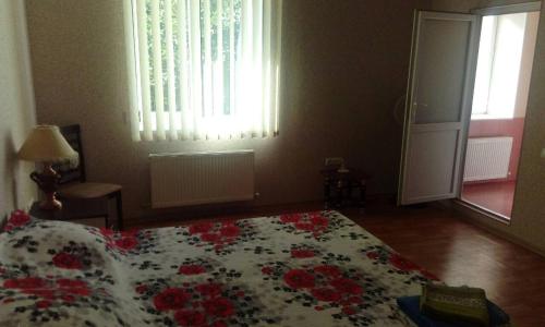 a bedroom with a bed with red flowers on it at Apartment on Mira avenue in Izmail
