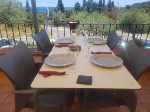 a table with plates and wine glasses on a balcony at Hostal Ondina in Begur