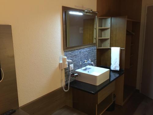 a bathroom with a sink and a mirror at Zys Hotel in Wettingen