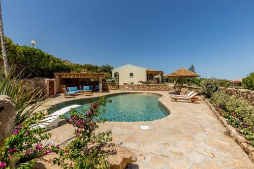 a backyard with a swimming pool and a patio at Hotel Costa Caddu in San Teodoro