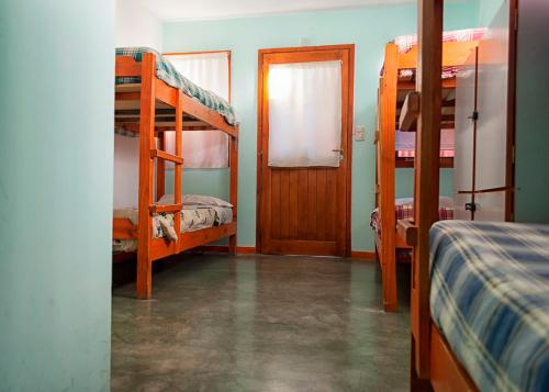 a room with two bunk beds and a door at Hostel Los Cormoranes in Ushuaia