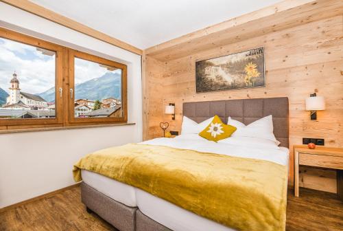 Schlafzimmer mit einem Bett und einem Fenster in der Unterkunft Hotel Augarten in Neustift im Stubaital