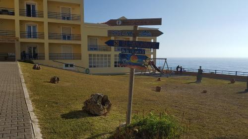 a street sign in front of a building next to the ocean at Hotel Apartamento Praia Azul in Santa Cruz