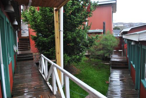 a wooden walkway leading to a yard with trees at Hostel Los Cormoranes in Ushuaia