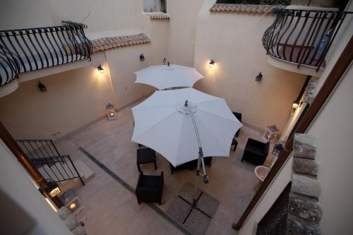 シラクーサにあるItaliana Resort Maniaceの白い傘2本の上から見える