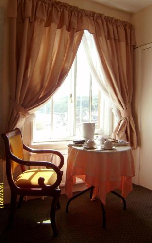 a table and a chair in front of a window at St Martins Guest House in Dover