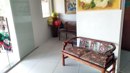 a bench in a room with a white tile floor at Pousada Miosotis in Nova Viçosa